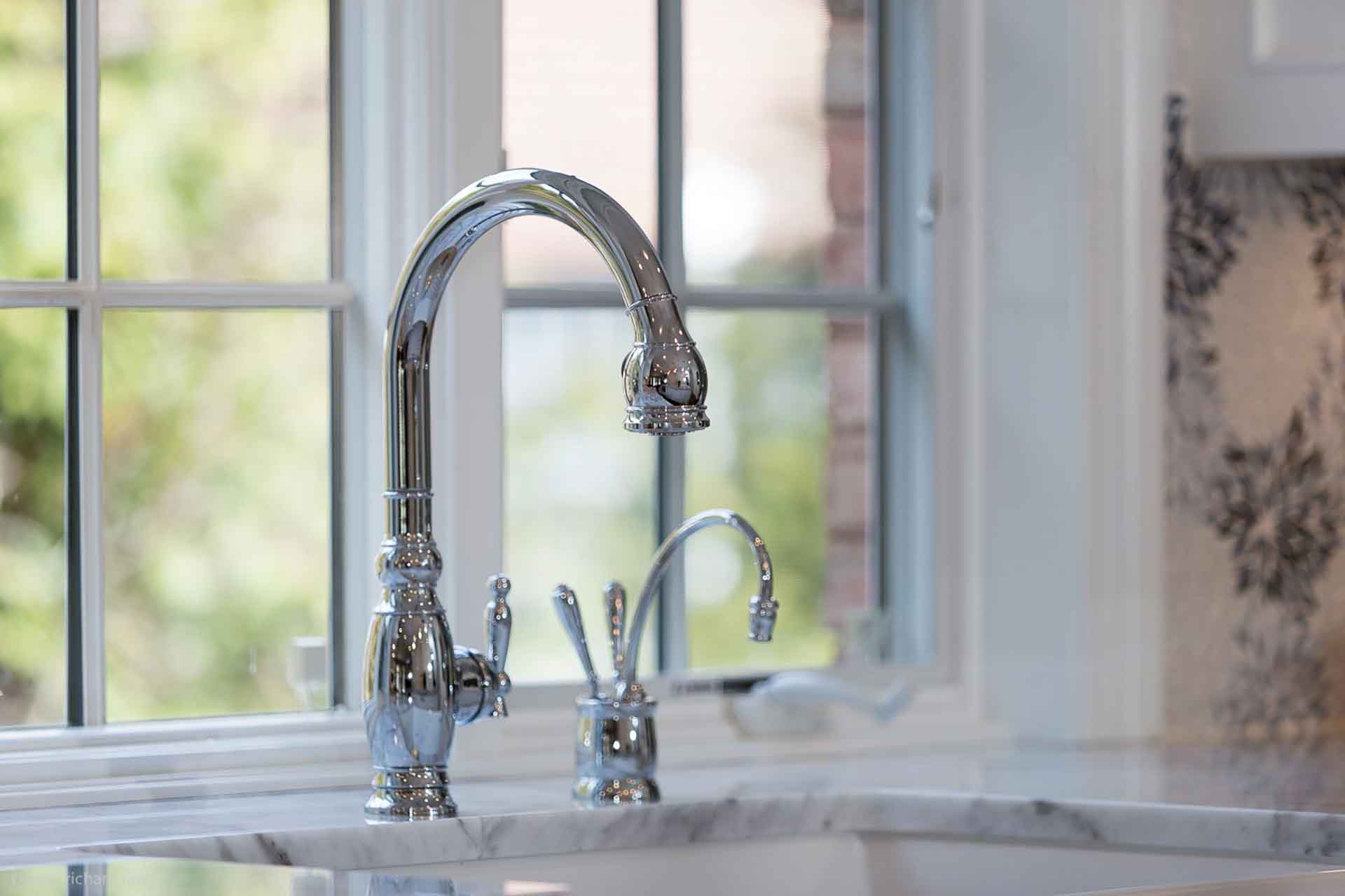 Closeup of kitchen faucet and granite countertop