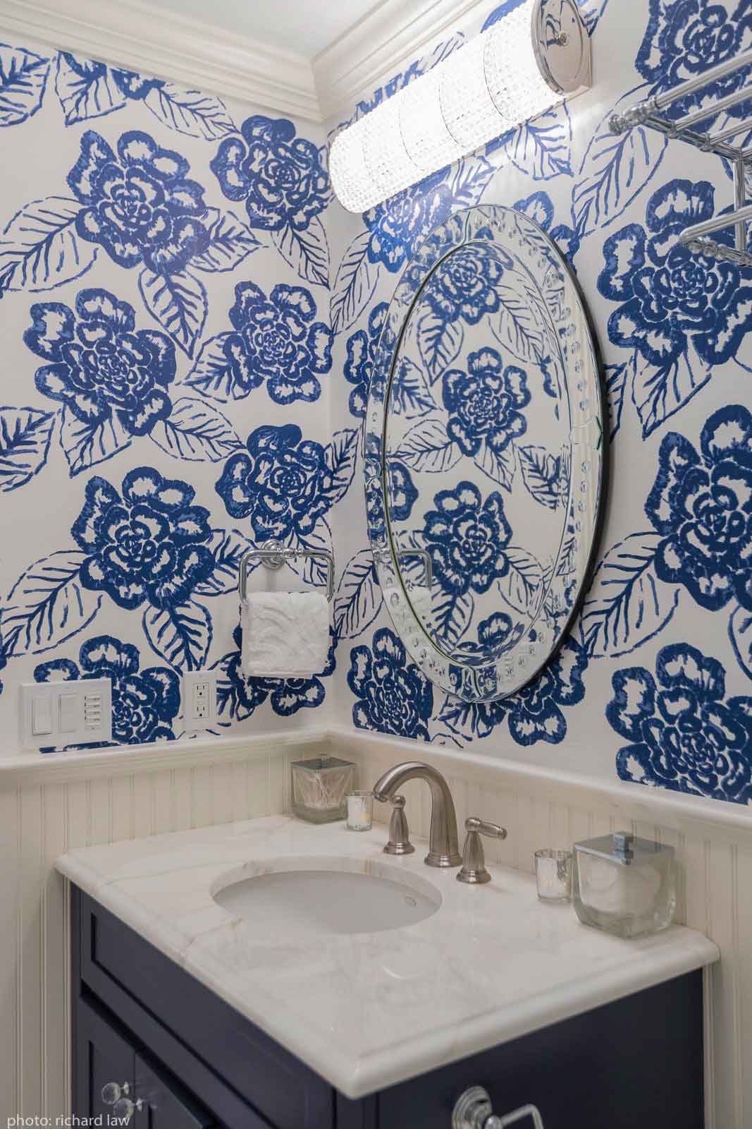 Bathroom sink, vanity, and blue flowered wallpaper