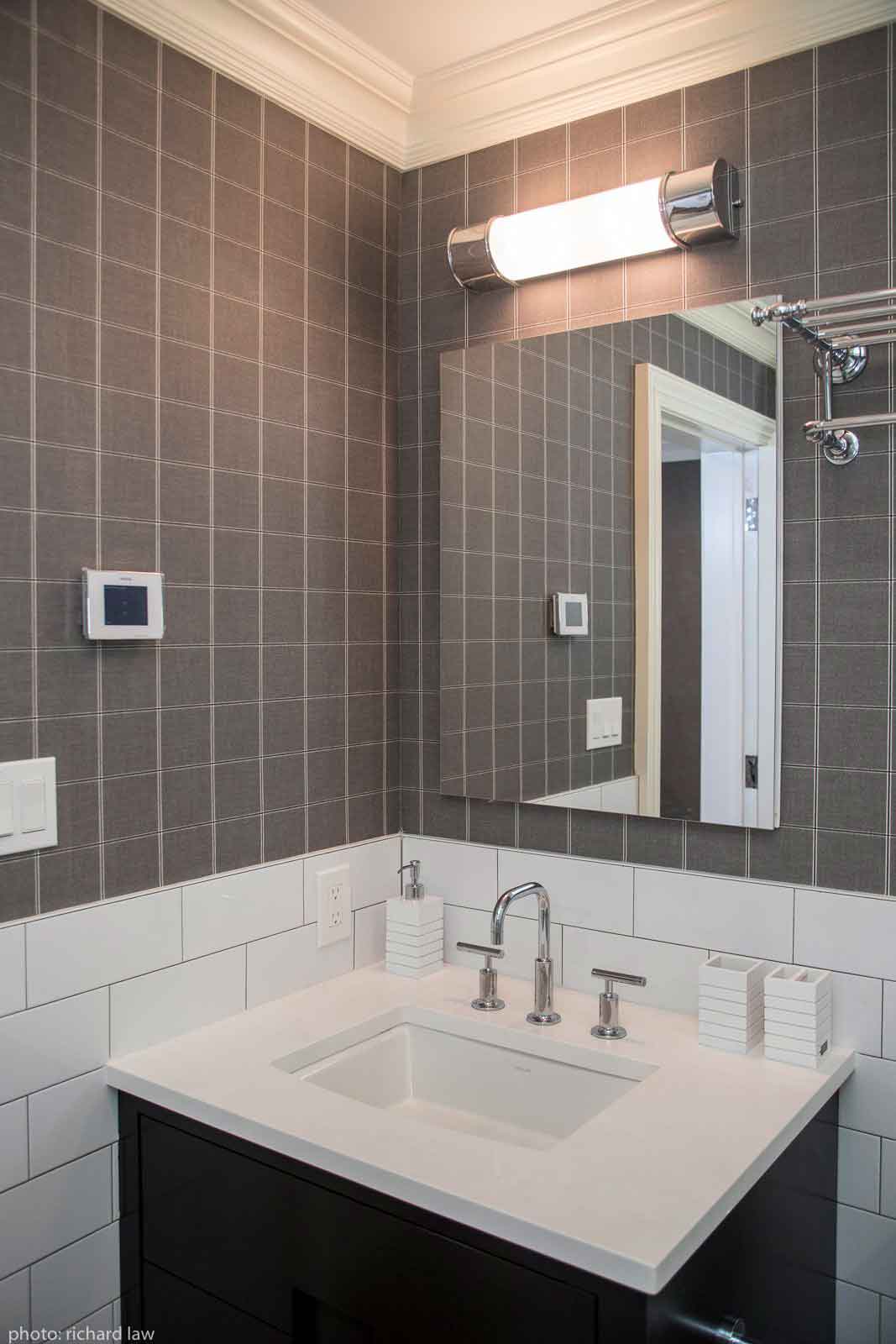 Bathroom sink, mirror and brown tiled walls